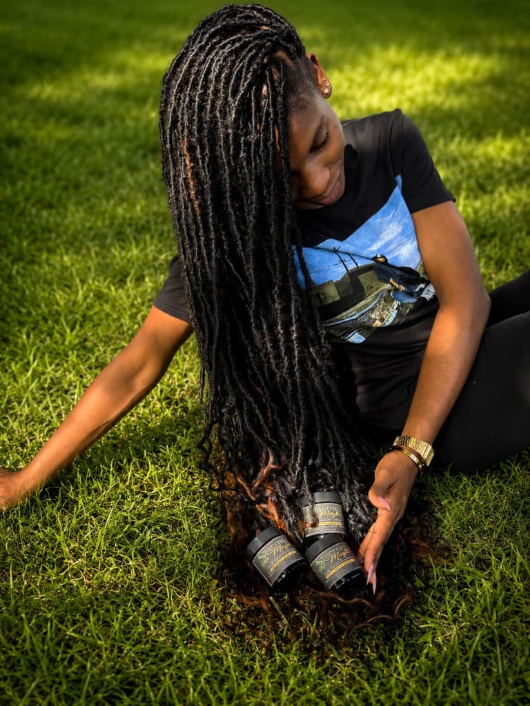 Woman with long locs enjoying Racmel Magic hair care outdoors